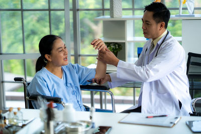 Female doctor examining patient in office