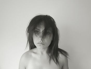 Young woman with tousled hair against white background