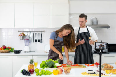 Friends standing on cutting board at home