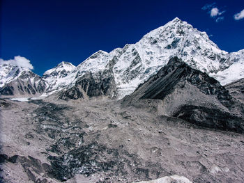 Scenic view of snowcapped mountains against blue sky