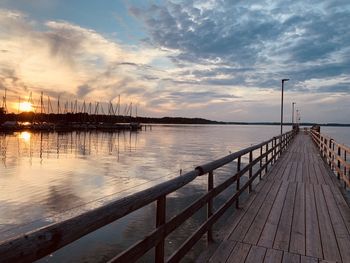 Pier over sea against sky during sunset