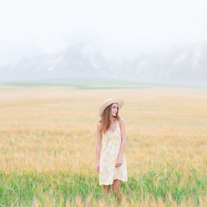 Woman standing on field against sky