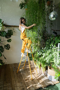 Woman with umbrella standing against plants