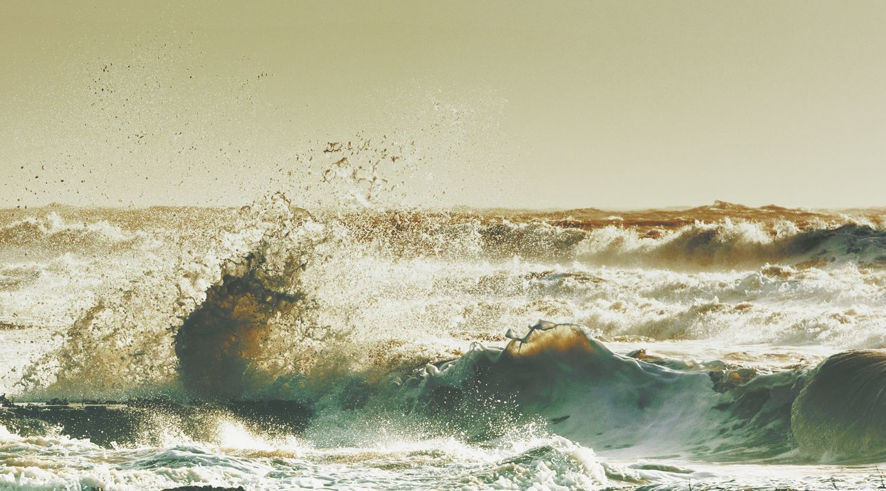 SEA WAVES SPLASHING AGAINST CLEAR SKY