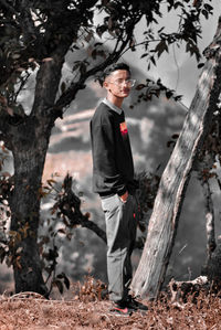 Boy standing on tree trunk