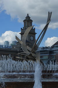 Water fountain against buildings in city