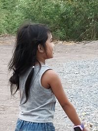 Side view of teenage girl standing on land