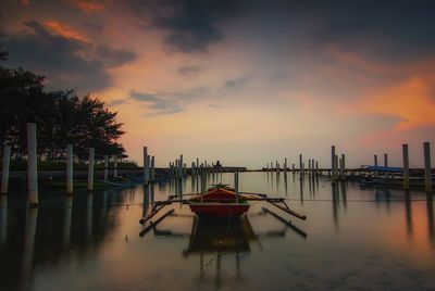 Boats moored in marina against sky during sunset