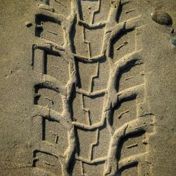 High angle view of tire track on sand