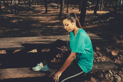 Woman listening music in forest