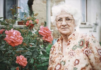 Portrait of woman on red flowering plants