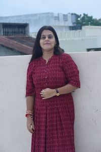 Portrait of young woman standing against wall