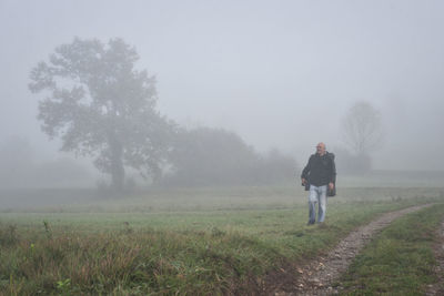 Man standing on field against sky