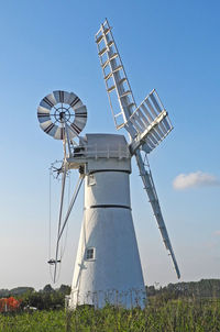 Low angle view of windmill on field against clear sky