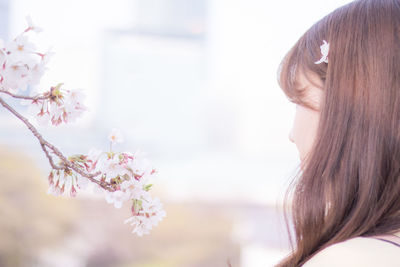 Close-up of woman with pink flower