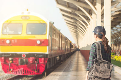 Rear view of woman standing at railroad station platform