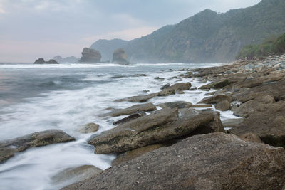 Rocks in sea against sky