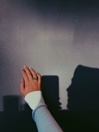 Cropped hand of woman against wall