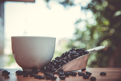 Close-up of coffee cup and beans on table