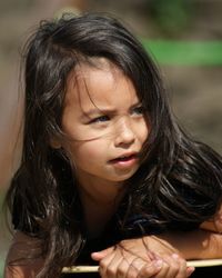 Close-up of cute girl looking away during sunny day