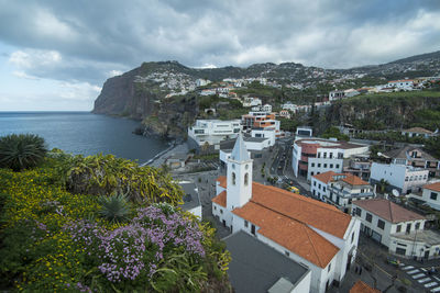 High angle view of townscape by sea against sky