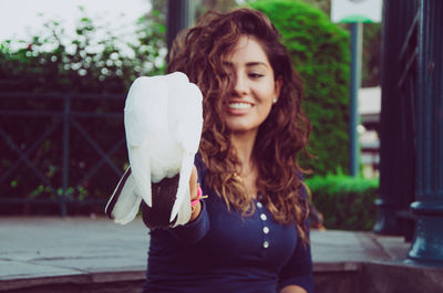 Bird perching on hand of woman