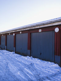Rows of colorful garages in sweden, blanketed by the fresh snowfall on a cold winter day 