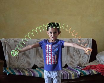 Action shot of a girl playing with a plastic rainbow spring toy