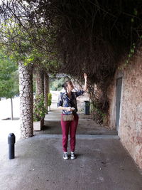 Full length of woman standing on tree trunk