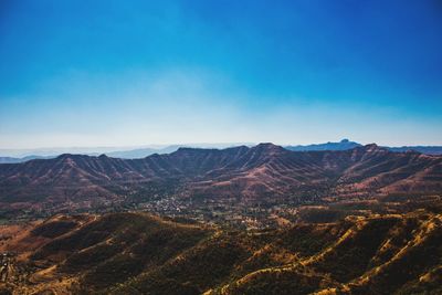 Scenic view of mountains against blue sky