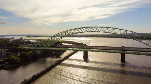 Bridge over river against sky during sunset