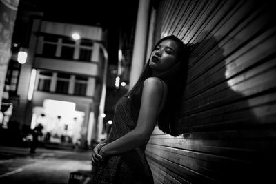 Young woman standing against shutter