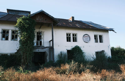 Abandoned house on field against clear sky