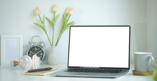 View of white and laptop on table at home