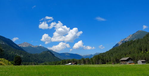 Scenic view of field and houses against sky