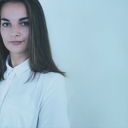 Portrait of young woman against white background