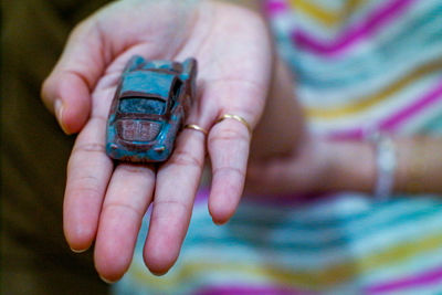 Midsection of woman holding toy car in hand