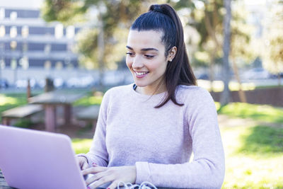 Young woman using phone while looking away