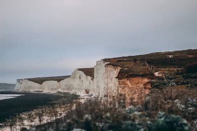 Scenic view of sea and cliff against clear sky