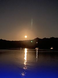 Scenic view of lake against clear sky at night