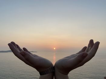 Low section of woman against sky during sunset