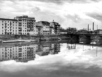 Reflection of buildings in river against sky