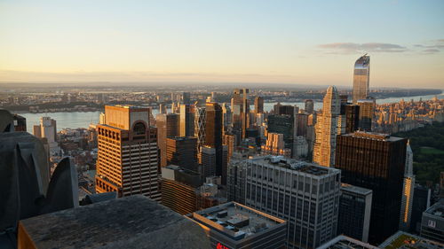 Aerial view of buildings in city against sky during sunset