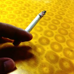 Close-up of human hand holding cigarette