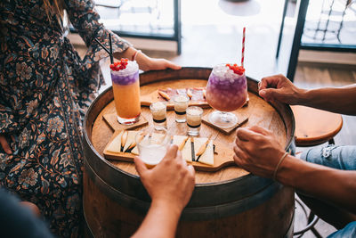 Midsection of woman holding ice cream on table