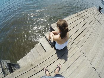 High angle view of woman photographing while standing on pier