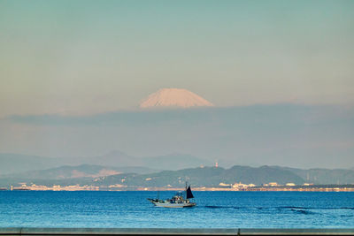 Sailboat sailing on sea against sky