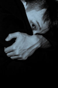 Close-up portrait of depressed man in dark room