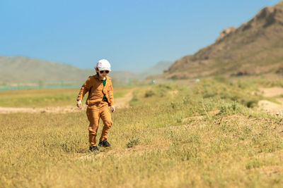 Rear view of woman standing on field