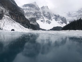 Surface level of frozen lake against mountain range during winter